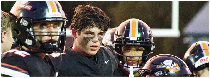 A football game is taking place on a field with players wearing blue and white uniforms. Description generated by AI