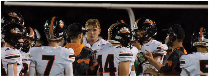 A football game is taking place on a field with players wearing blue and white uniforms. Description generated by AI