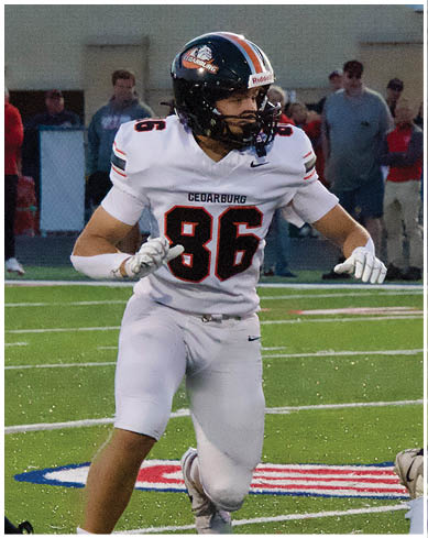 A football player wearing a blue and red jersey. Description generated by AI