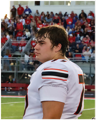A football player wearing a blue and red jersey. Description generated by AI