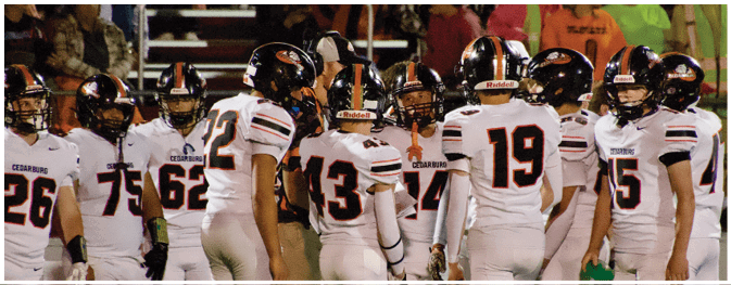 A group of football players on a field. Description generated by AI