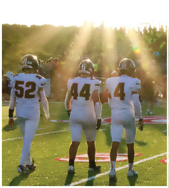 A group of football players celebrating a touchdown. Description generated by AI