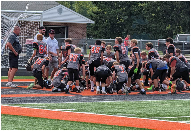A group of football players on a field. Description generated by AI