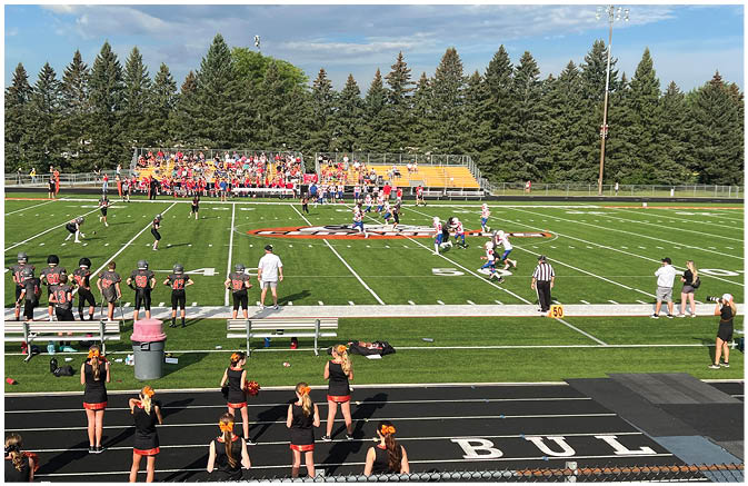 A group of football players on a field. Description generated by AI