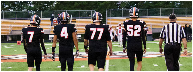 A football game is taking place on a field with players wearing blue and white uniforms. Description generated by AI