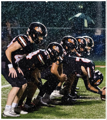 A group of football players celebrating a touchdown. Description generated by AI