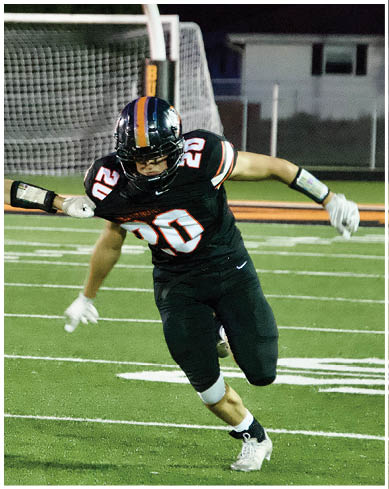 A football player wearing a blue and red jersey. Description generated by AI