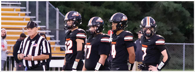 A football game is taking place on a field with players wearing blue and white uniforms. Description generated by AI