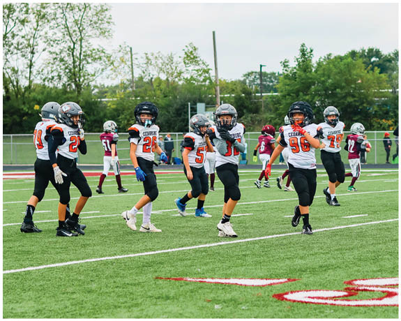 A group of football players on a field. Description generated by AI