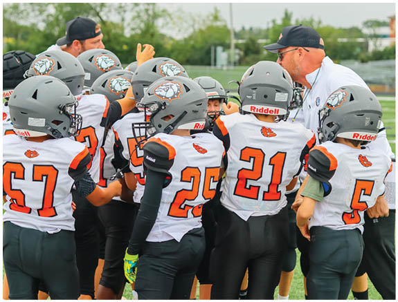 A group of football players on a field. Description generated by AI