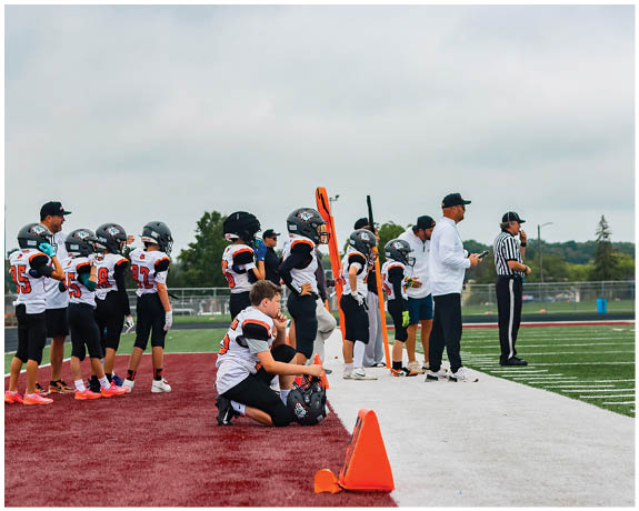 A group of football players on a field. Description generated by AI