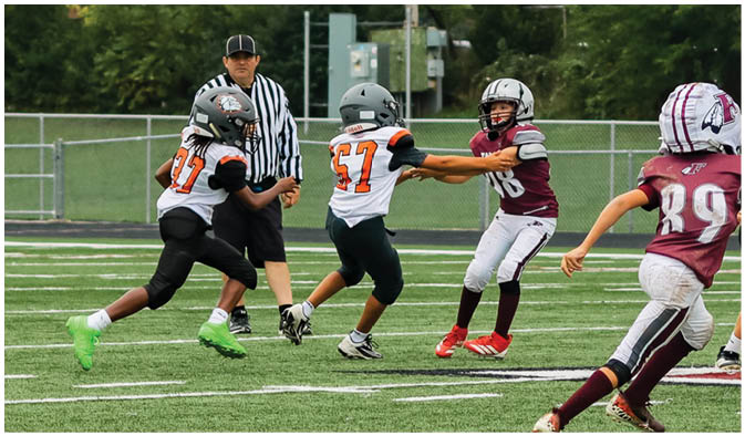 A football game is taking place on a field with players wearing blue and white uniforms. Description generated by AI