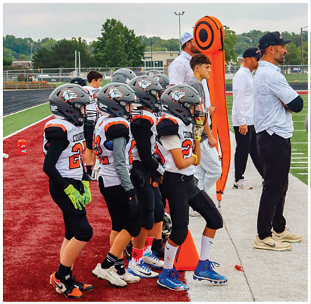 A group of football players celebrating a touchdown. Description generated by AI
