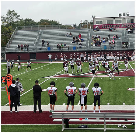 A group of football players celebrating a touchdown. Description generated by AI