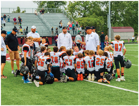 A group of football players on a field. Description generated by AI