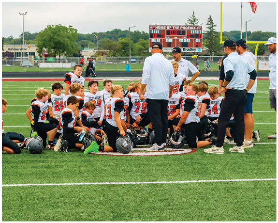 A group of football players on a field. Description generated by AI