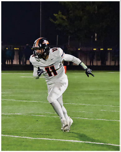 A football player wearing a blue and red jersey. Description generated by AI
