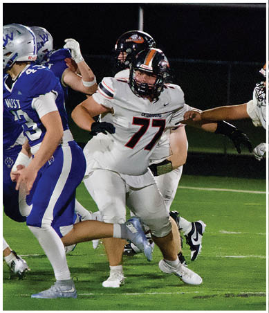 A football player wearing a blue and red jersey. Description generated by AI