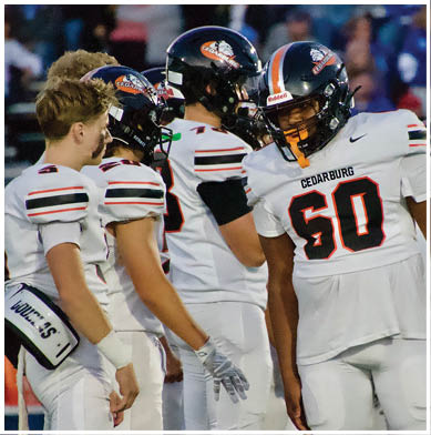 A football game is taking place with a group of men on the field. Description generated by AI