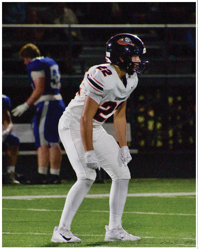 A football player wearing a blue and red jersey. Description generated by AI