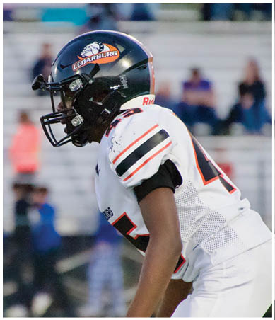 A football player wearing a blue and red jersey. Description generated by AI