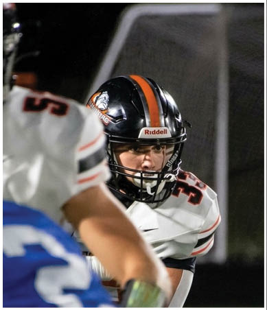 A football player wearing a blue and red jersey. Description generated by AI