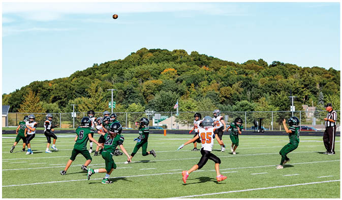 A football game is taking place on a field with players wearing blue and white uniforms. Description generated by AI