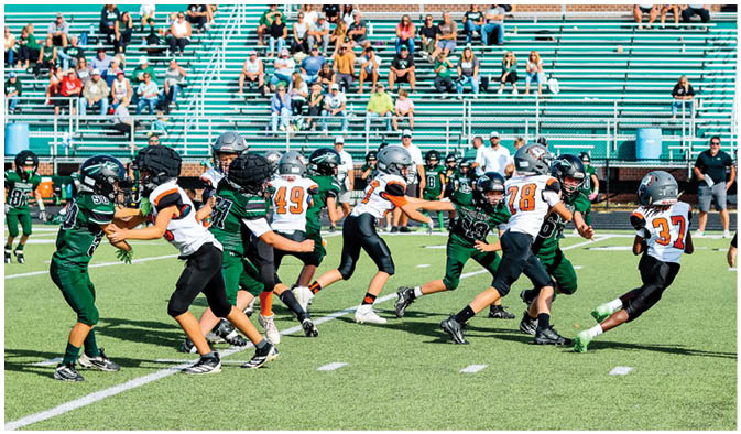 A football game is taking place on a field with players wearing blue and white uniforms. Description generated by AI