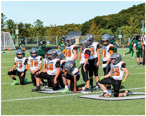 A group of football players on a field. Description generated by AI