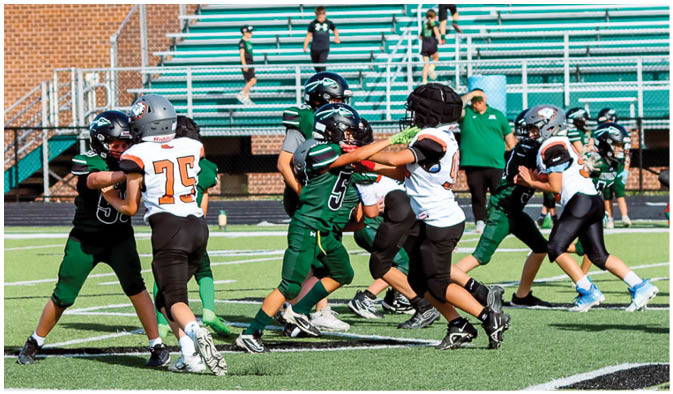 A football game is taking place on a field with players wearing blue and white uniforms. Description generated by AI