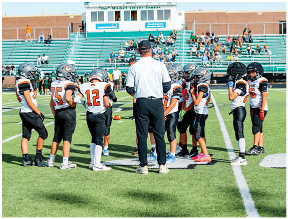 A group of football players on a field. Description generated by AI