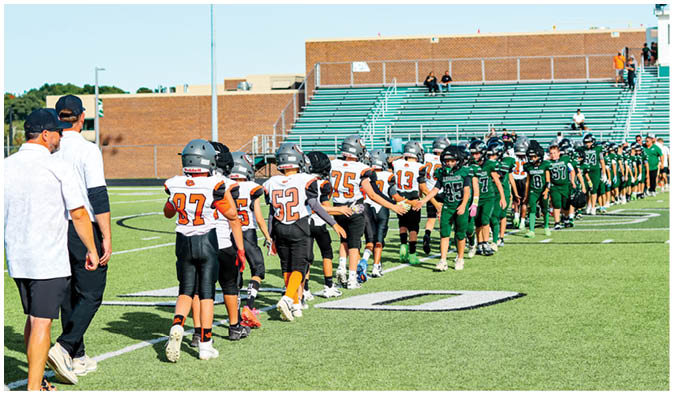 A football game is taking place on a field with players wearing blue and white uniforms. Description generated by AI