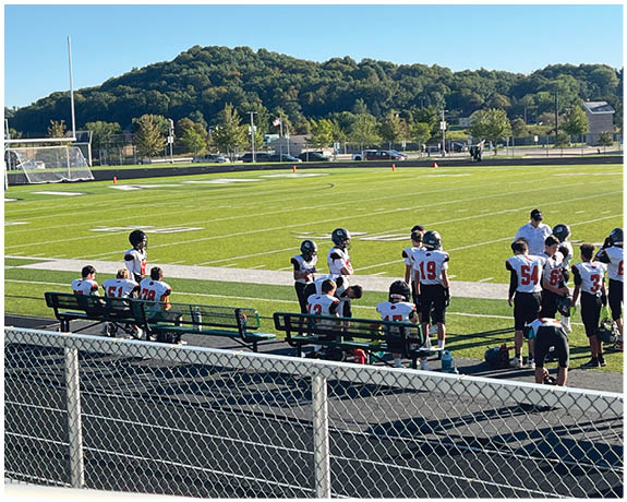 A group of football players on a field. Description generated by AI