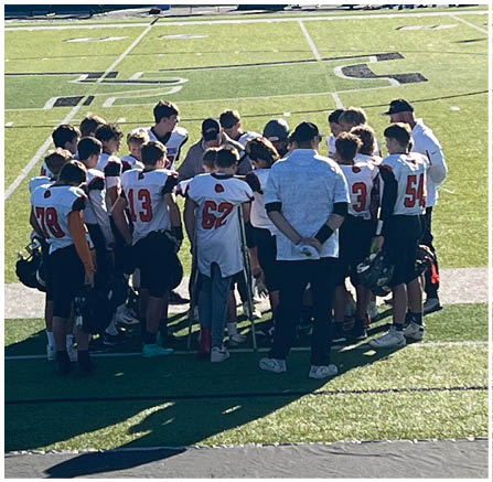 A group of football players celebrating a touchdown. Description generated by AI