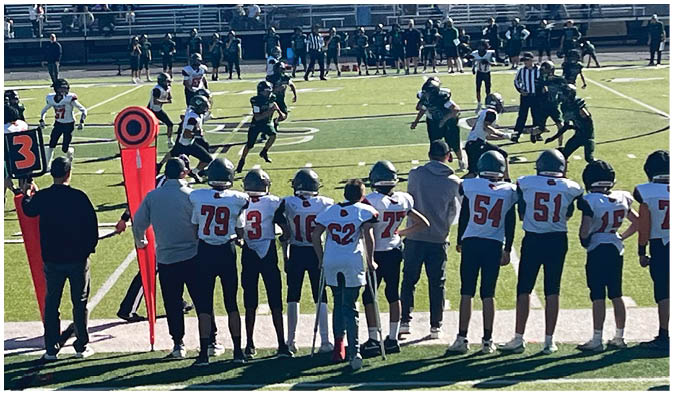 A football game is taking place on a field with players wearing blue and white uniforms. Description generated by AI