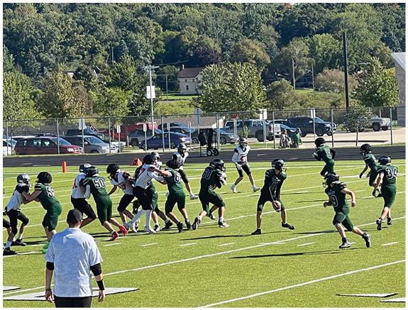 A group of football players on a field. Description generated by AI