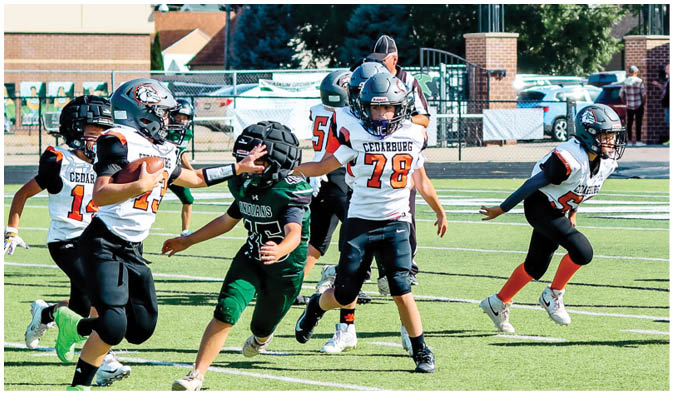 A football game is taking place on a field with players wearing blue and white uniforms. Description generated by AI