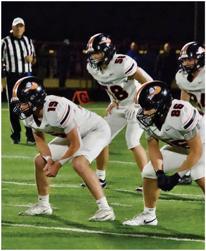 A group of football players on a field. Description generated by AI