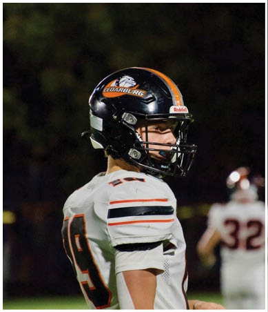 A football player wearing a blue and red jersey. Description generated by AI