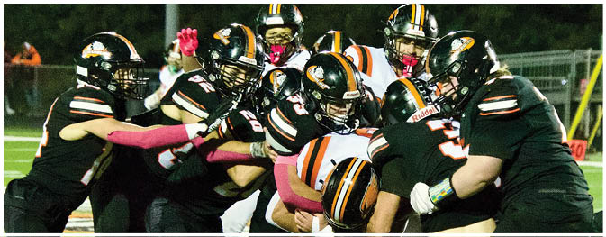 A group of football players on a field. Description generated by AI