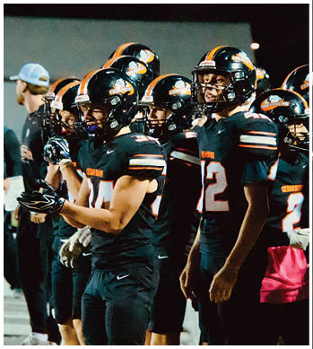 A group of football players celebrating a touchdown. Description generated by AI