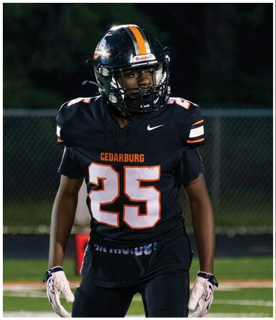 A football player wearing a blue and red jersey. Description generated by AI