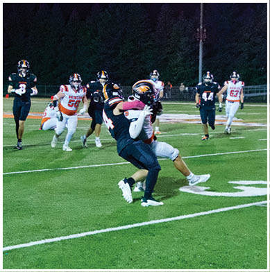 A football game is taking place with a group of men on the field. Description generated by AI