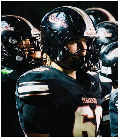 A football player wearing a blue and red jersey. Description generated by AI