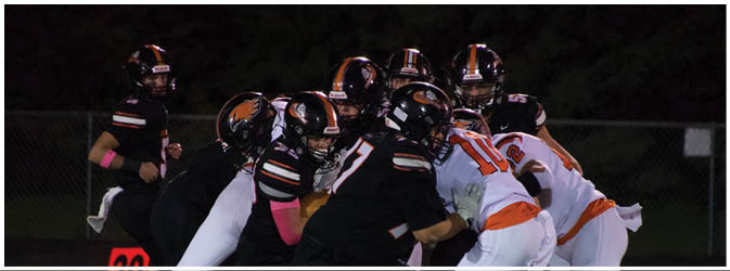 A football game is taking place on a field with players wearing blue and white uniforms. Description generated by AI