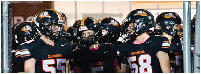 A football game is taking place on a field with players wearing blue and white uniforms. Description generated by AI