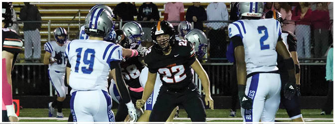 A football game is taking place on a field with players wearing blue and white uniforms. Description generated by AI