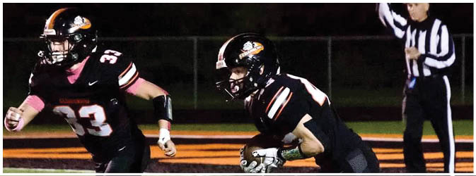 A football game is taking place on a field with players wearing blue and white uniforms. Description generated by AI