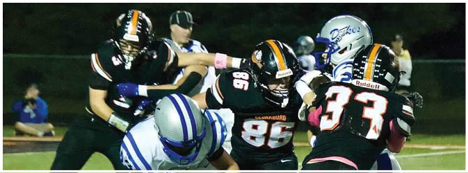 A football game is taking place on a field with players wearing blue and white uniforms. Description generated by AI