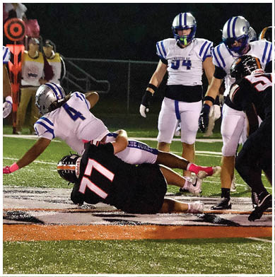 A football game is taking place with a group of men on the field. Description generated by AI